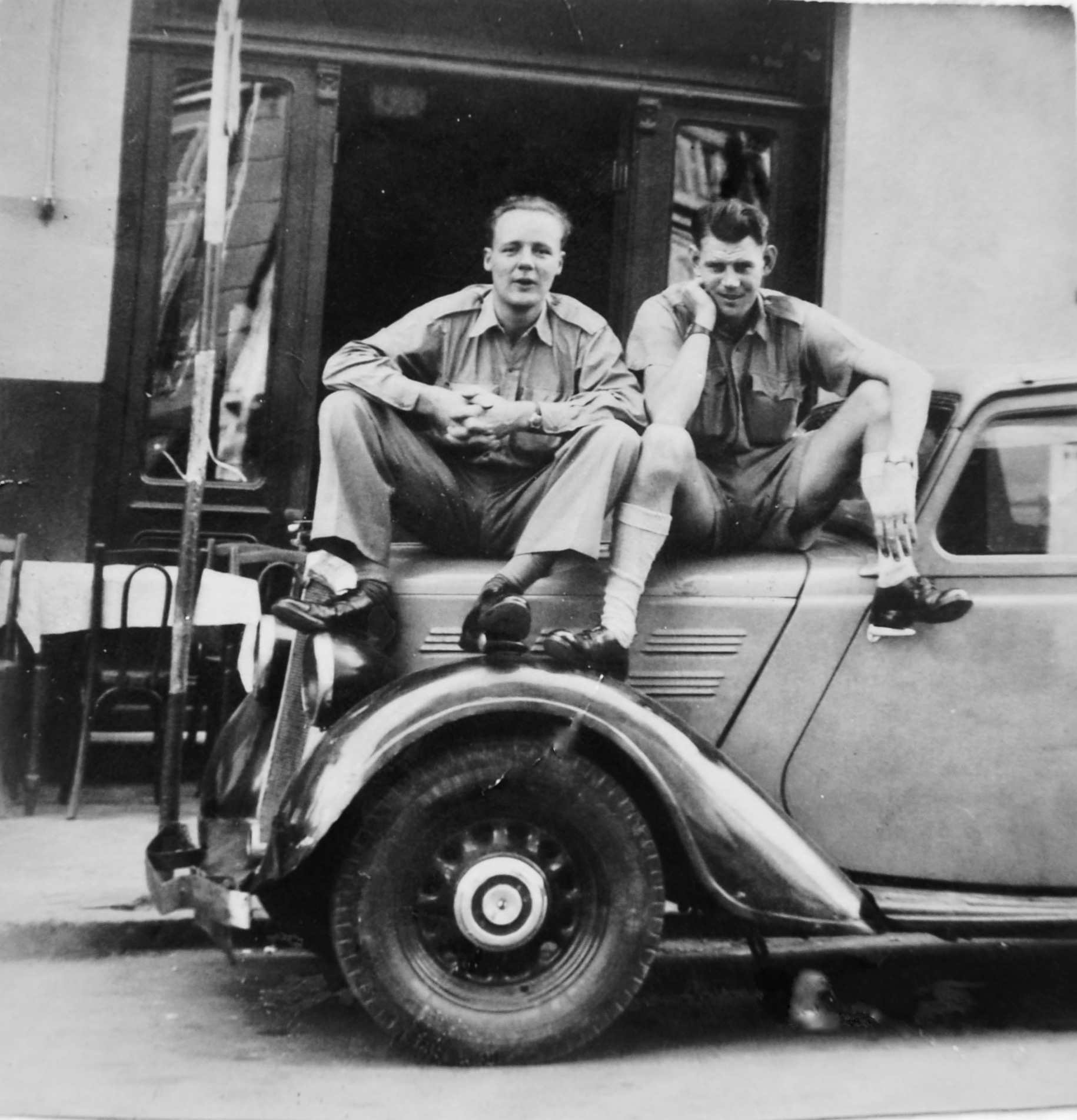 Ron Chapman sitting on car(right). Location-date unknown.